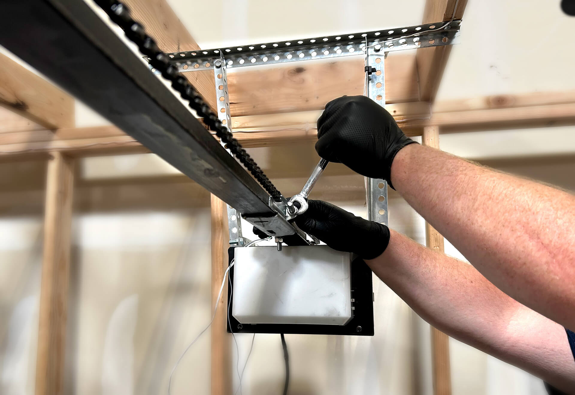 Garage door technician repairing motorized opener with precision tools