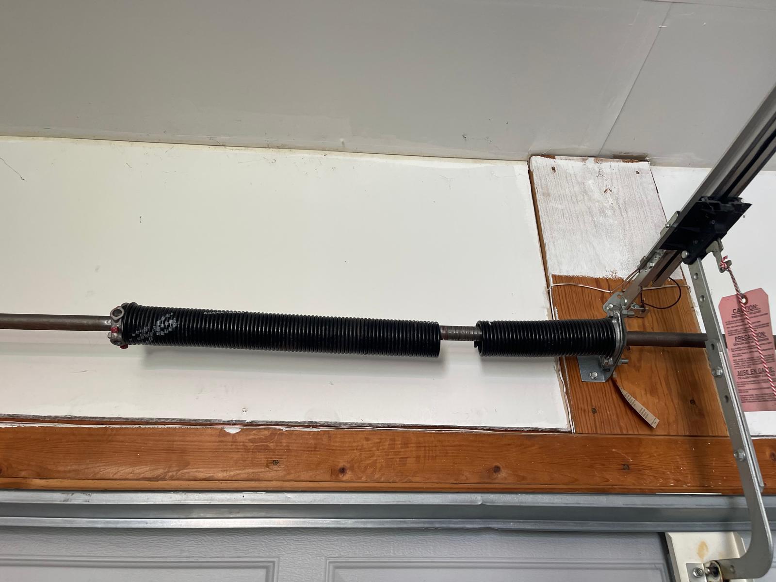Broken garage door torsion spring above single door