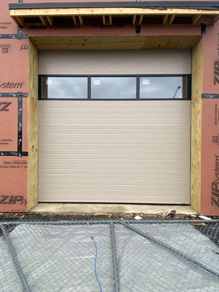 Installed commercial garage door with top glass panel – exterior front view