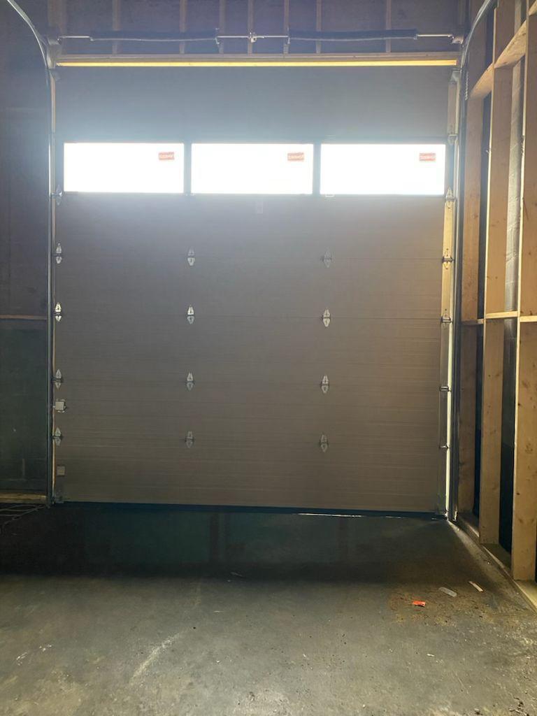 Interior view of newly installed commercial garage door with upper glass section