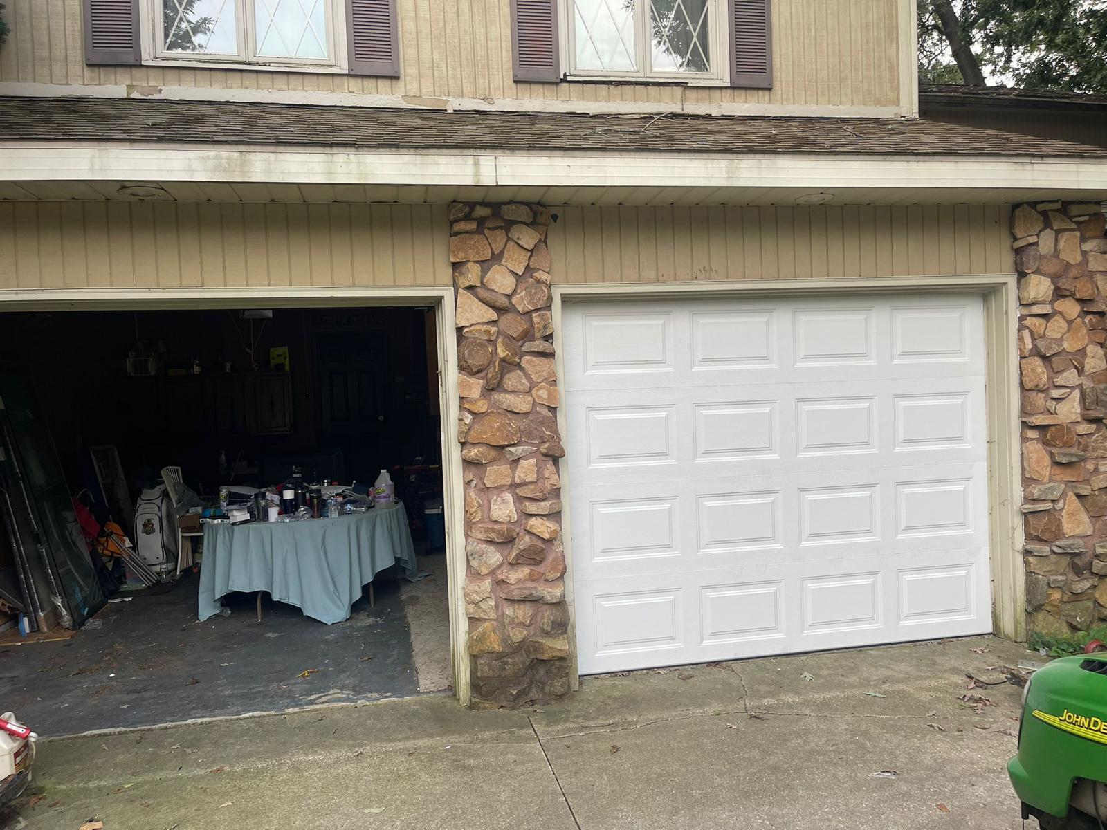 Front view of a newly installed white garage door – completed installation